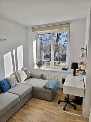 a living room with a couch and a desk and a window at Alėjos Apartmentai Comfort in Druskininkai