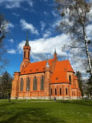 a large brick church with an orange roof at Alėjos Apartmentai Comfort in Druskininkai