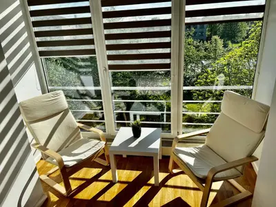 two chairs and a table in front of a window at Vilniaus 96 apartments in Ukmergė