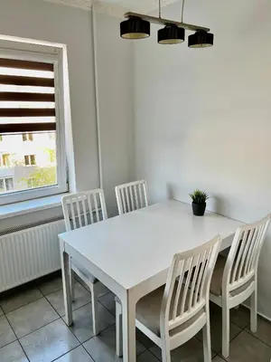 a white table and chairs in a room with a window at Vilniaus 96 apartments in Ukmergė