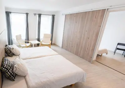 a bedroom with two beds and a sliding glass door at Old Town apartments/Senamiesčio apartamentai in Ukmergė