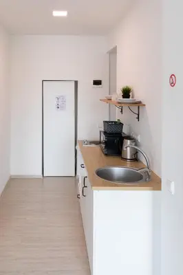 a kitchen with a sink and a white refrigerator at Old Town apartments/Senamiesčio apartamentai in Ukmergė