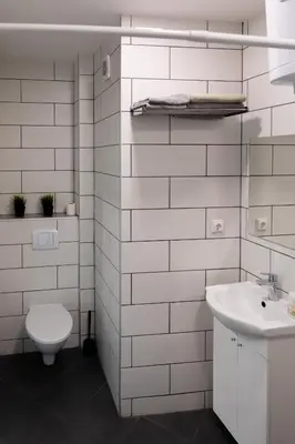 a white bathroom with a toilet and a sink at Old Town apartments/Senamiesčio apartamentai in Ukmergė