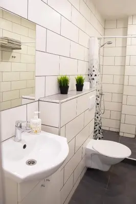 a white bathroom with a sink and a toilet at Old Town apartments/Senamiesčio apartamentai in Ukmergė