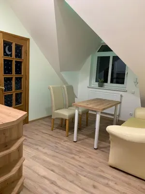 a dining room with a table and chairs and a window at Green house Ramuciai in Ramučiai