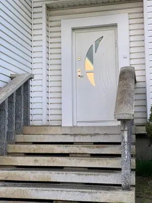 a front door of a house with an umbrella on the door at Green house Ramuciai in Ramučiai