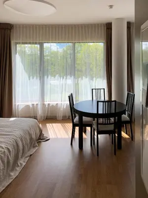 a bedroom with a table and chairs and a bed at Park Apartments in Druskininkai