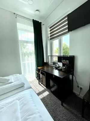 a bedroom with a desk and a bed and a window at Green apartments Easy Kaunas in Kaunas