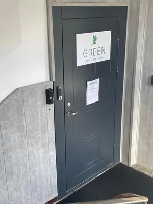 a black door with a green sign on it at Green apartments Easy Kaunas in Kaunas