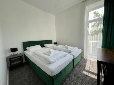 a bedroom with a green and white bed with a window at Green apartments Easy Kaunas in Kaunas