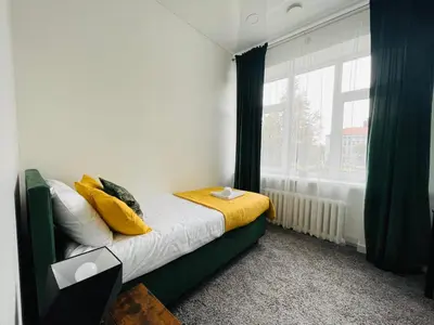 a bedroom with a bed with yellow pillows and a window at Green apartments Easy Kaunas in Kaunas