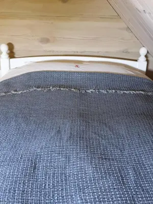 a bed with a bed frame with a blue checked mattress at Amatų kalnelis in Anykščiai