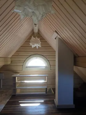 an attic room with a ceiling with a window at Amatų kalnelis in Anykščiai