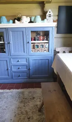 a blue cabinet with dishes inside of it at Amatų kalnelis in Anykščiai