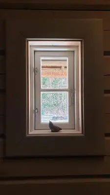 a window with a shoe sitting on a window sill at Amatų kalnelis in Anykščiai