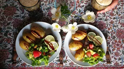 a table with two plates of food and a salad at Amatų kalnelis in Anykščiai