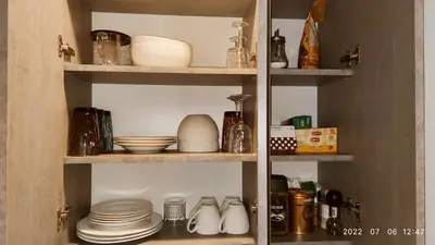 a shelf with dishes and other items in a kitchen at HaPPy Inn Laime Studio, Self Check-In-24-7, A-C, Parking-in-the-underground-Garage in Vilnius