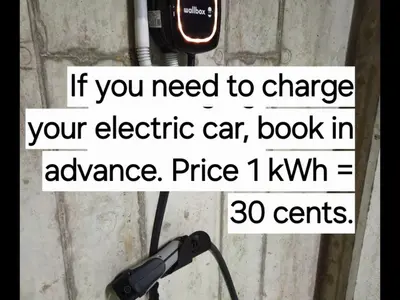 a sign that says if you need to charge your electric car book in advance at HaPPy Inn Laime Studio, Self Check-In-24-7, A-C, Parking-in-the-underground-Garage in Vilnius