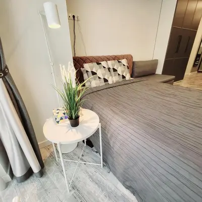 a bedroom with a bed and a table with a plant at HaPPy Inn Laime Studio, Self Check-In-24-7, A-C, Parking-in-the-underground-Garage in Vilnius