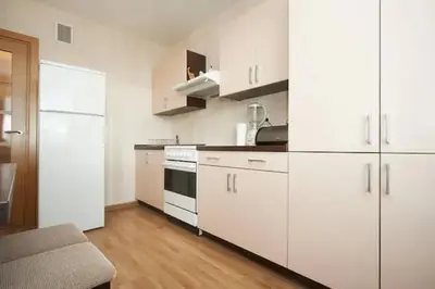 a kitchen with white cabinets and white appliances at Cozy private room in a three room apartment Free parking Feel like at home in Vilnius