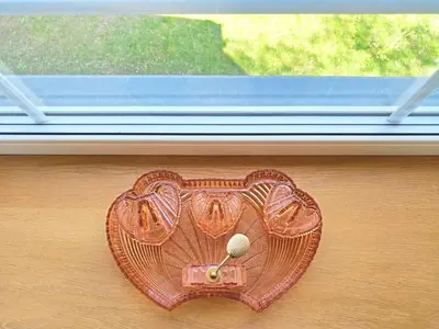 a heart shaped purse sitting on the floor next to a window at Suite with private bathroom at three bedroom interwar Villa Grabyte with daily spaces to share by pine forest on the bank of the river- 8min by car from old town in Kaunas