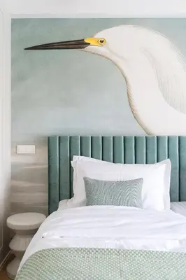 a large white bird is hanging over a bed at Suite with private bathroom at three bedroom interwar Villa Grabyte with daily spaces to share by pine forest on the bank of the river- 8min by car from old town in Kaunas