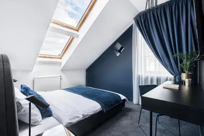 a bedroom with a bed and a desk and window at Berman House in Kaunas