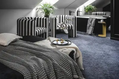 a bedroom with striped chairs and a bed and a table at Berman House in Kaunas