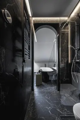 a black bathroom with a toilet and a sink at Berman House in Kaunas
