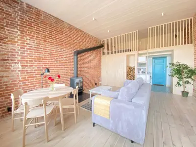a living room with a brick wall and a blue couch at Traukinių namai #2 in Švenčionėliai