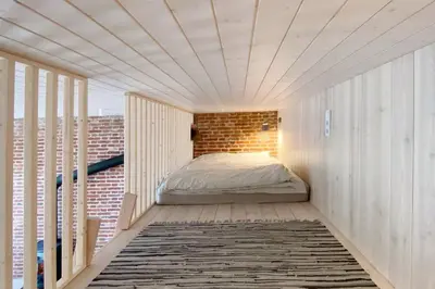 a bed in a room with a brick wall at Traukinių namai #2 in Švenčionėliai