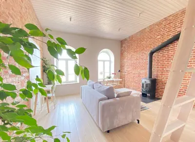 a living room with a couch and a brick wall at Traukinių namai #2 in Švenčionėliai