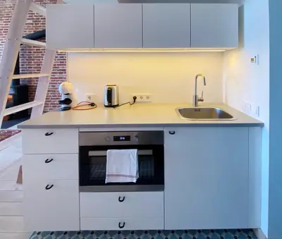 a kitchen with white cabinets and a sink at Traukinių namai #2 in Švenčionėliai