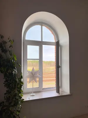 an arched window with a star on a window sill at Traukinių namai #2 in Švenčionėliai