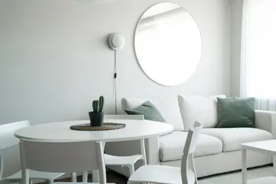 a white living room with a table and a couch at Grey Green Cozy Apartment in Birštonas