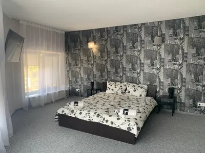 a bedroom with a bed with a black and white wallpaper at Hotel Marijampole in Marijampolė