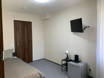 a bedroom with a bed and a flat screen tv at Hotel Marijampole in Marijampolė