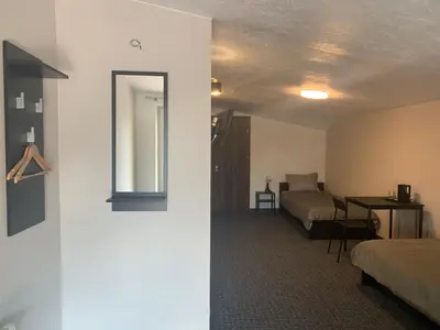 a room with a bed and a table and a mirror at Hotel Marijampole in Marijampolė