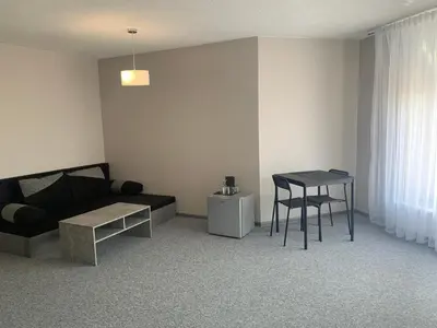 a living room with a couch and a table at Hotel Marijampole in Marijampolė
