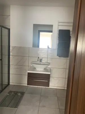 a white bathroom with a sink and a window at Hotel Marijampole in Marijampolė