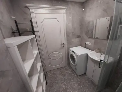 a bathroom with a toilet sink and a washing machine at Gilužio Rivjera in Vilnius