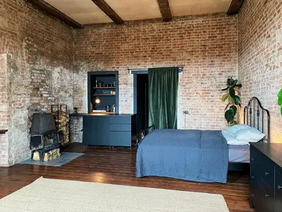 a bedroom with a bed and a brick wall at Traukinių namai #1 in Švenčionėliai