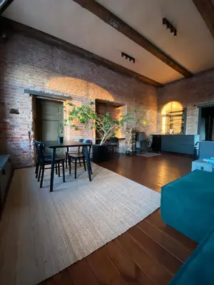 a room with a table and chairs and a brick wall at Traukinių namai #1 in Švenčionėliai