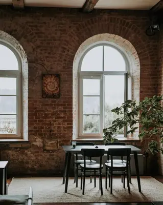 a brick room with a table and chairs and windows at Traukinių namai #1 in Švenčionėliai