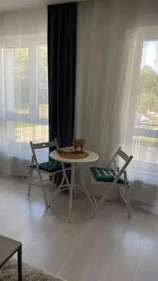 a table and chairs in a living room with a window at Ozo flat in Vilnius