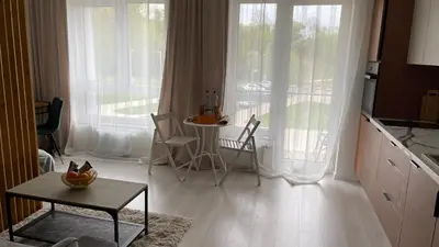 a kitchen with a table and chairs and a balcony at Ozo flat in Vilnius