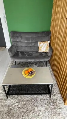 a bowl of fruit on a coffee table in front of a couch at Ozo flat in Vilnius