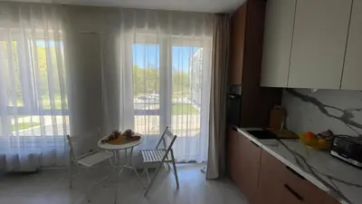a kitchen with a table and chairs in front of a window at Ozo flat in Vilnius