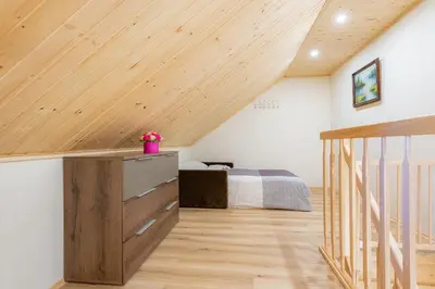 a bedroom with a bed and a wooden ceiling at Senamiesčio apartamentai in Druskininkai