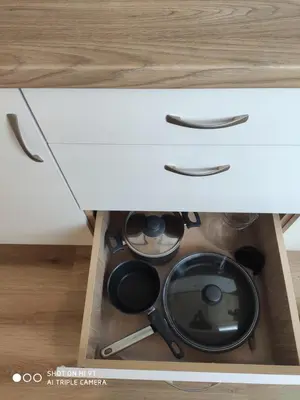 a drawer with pots and pans in a cabinet at Senamiesčio apartamentai in Druskininkai